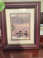 Full view of framed print standing on table