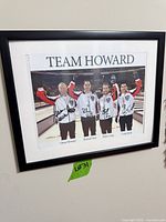 Framed signed Team Howard photo on wall