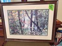 Full view of framed woodland print on table