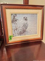Full view of framed snowy owl print on tabletop