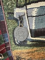 Close-up of woven Glen Abbey Golf Club medallion tag on tapestry