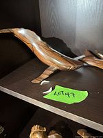 Side view of wooden whale on shelf with detached white inlay pieces visible