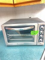 Front view of KitchenAid stainless steel toaster oven with glass door and handle