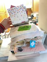 Stack of assorted linens with confetti paper napkins on top
