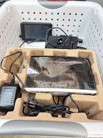 Overall contents in basket: GPS unit, weather station display in molded tray, additional device, cables and adapters