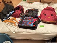 Group shot of all bags and hangers on bed