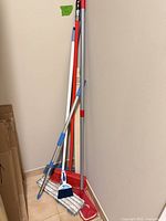 All five cleaning tools leaning against wall