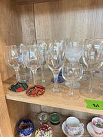 Shelf view of assorted stemmed glasses and coasters