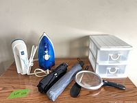 Group shot of all items: iron, steamer, organizer, two umbrellas, magnifying glass, shoehorn