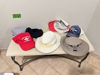 Six hats displayed on table showing colors, styles and condition