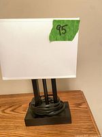 Front view showing white shade, black base, cord