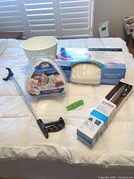 All items on bed: grab bar box, reacher, leg pillow box, ergonomic pillow package, white planter