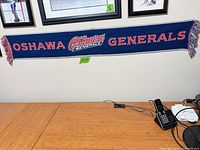 Full view of Oshawa Generals scarf hung horizontally showing complete text and fringed ends