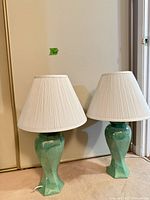 Both seafoam green lamps with shades front view