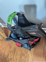 Top view of black fabric tote showing various handled screwdrivers, pliers, and plastic tool case