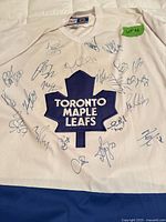 Full view of signed jersey front showing crest and autographs