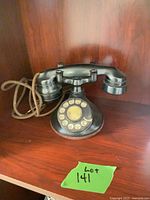 Full view of vintage black rotary telephone on shelf