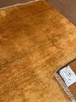 Corner close-up showing wool pile, fringe and label