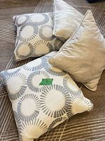 Group of four cushions, two patterned, two solid cream