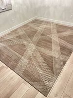 Full view of rug placed on light wood floor showing overall color and pattern