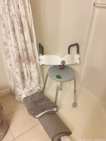 Shower stool, raised toilet seat, two bath mats inside shower
