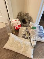 Group view of pillows, wreath, cone trees, hook