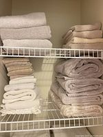 Stacks of cream and beige towels on wire shelves