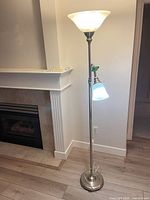 Full view of brass-tone floor lamp with both lights on