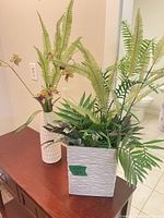 Both ceramic vases with artificial arrangements on table
