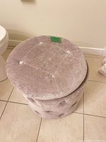Closed stool showing grey velvet upholstery and tufting