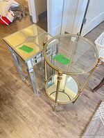 Mirrored square accent table and round two-tier glass table side by side