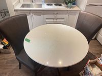 Full view of round quartz top table with two chairs