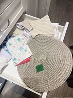 Drawer view showing braided placemat and folded tea towels