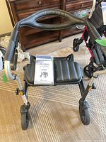 Front view of black Evolution Trillium walker showing seat, push bar and wheels