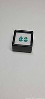Pair of pear-cut emeralds in black display box