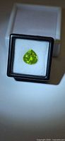 Front view of loose pear-cut peridot in case