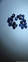 Group of small round blue sapphire cabochons displayed on neutral background