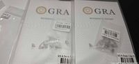 Close view of two GRA moissanite report cards with earrings in plastic sleeves