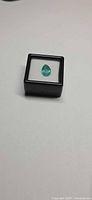 Pear cut emerald in display box, top view