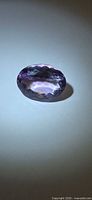 Top view of faceted amethyst showing oval cut and color