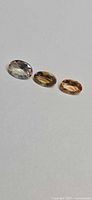 Three loose oval tanzanite gemstones on white background
