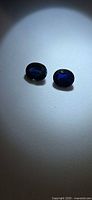 Pair of loose oval sapphires captured under spotlight