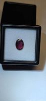 Loose oval rubelite gemstone in square gem box