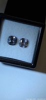 Pair of light purple cushion-cut spinels in display case