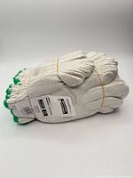 Bundle of 12 pairs of white knit work gloves with green cuffs