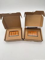 Two open cardboard boxes each holding 8 Amazon Basics AAA batteries