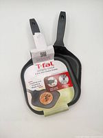 Front view of two identical T-fal mini cheese griddles with packaging