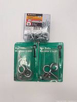 All three unopened hardware packs: two eye bolt packs and one tub of screws