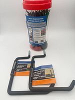 Tub of cable ties and two utility hangers together