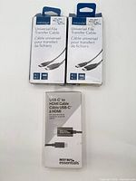 Front view of two Insignia Universal File Transfer Cable boxes and one Best Buy essentials USB-C to HDMI Cable box